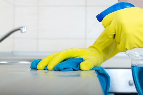 Cleaner wearing PPE while treating a carpet safely